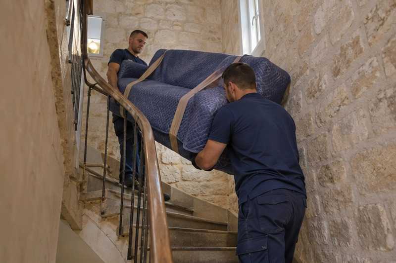 Canapé passé par-dessus la rampe : chantier Rue Ambroise Paré