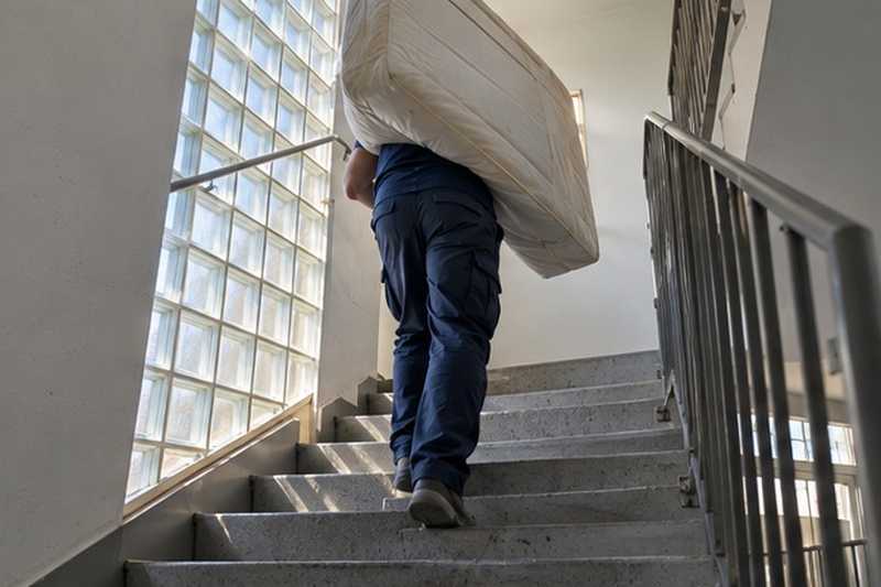Matelas porté dans la cage d’escalier : chantier Rue Charles Péguy