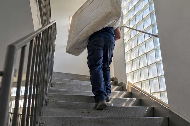 Matelas porté dans la cage d’escalier : chantier Rue de l’Étang de la Loy